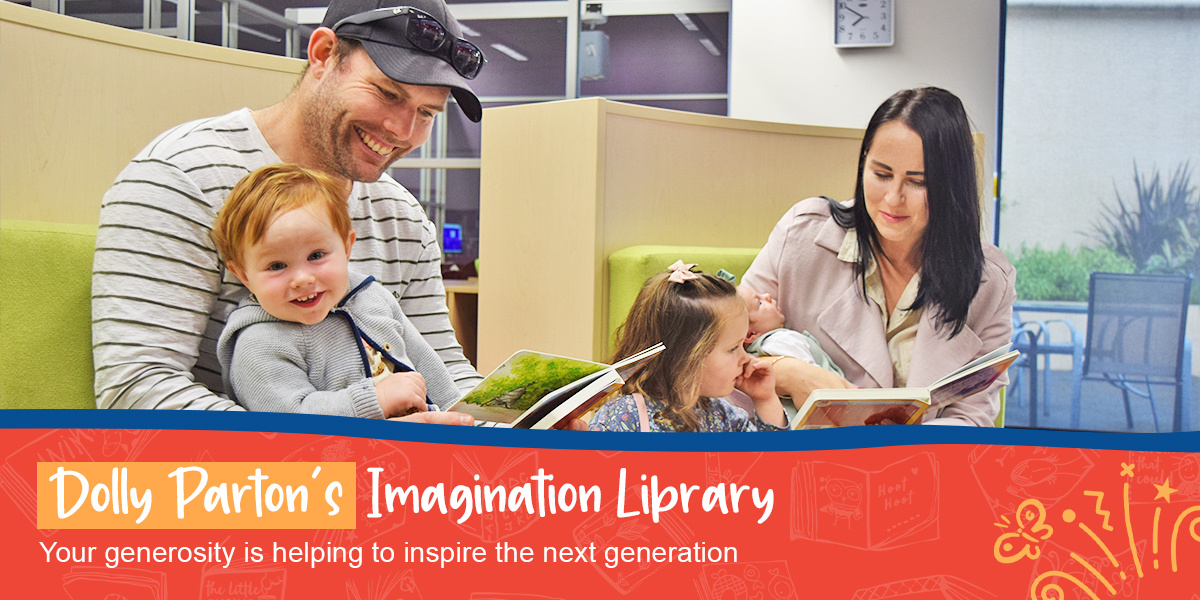 A family sit reading picture books together